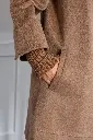 Main glissée dans une poche en laine camel.webp