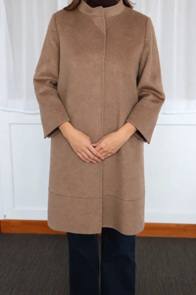 Portrait mode d’un manteau camel en intérieur.webp