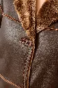 Détail texturé d’un manteau en cuir et shearling.webp