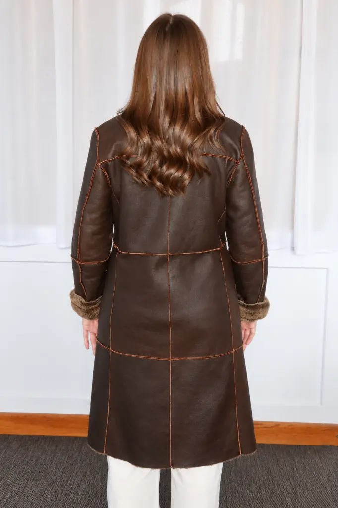Manteau aviateur brun et cheveux ondulés.webp